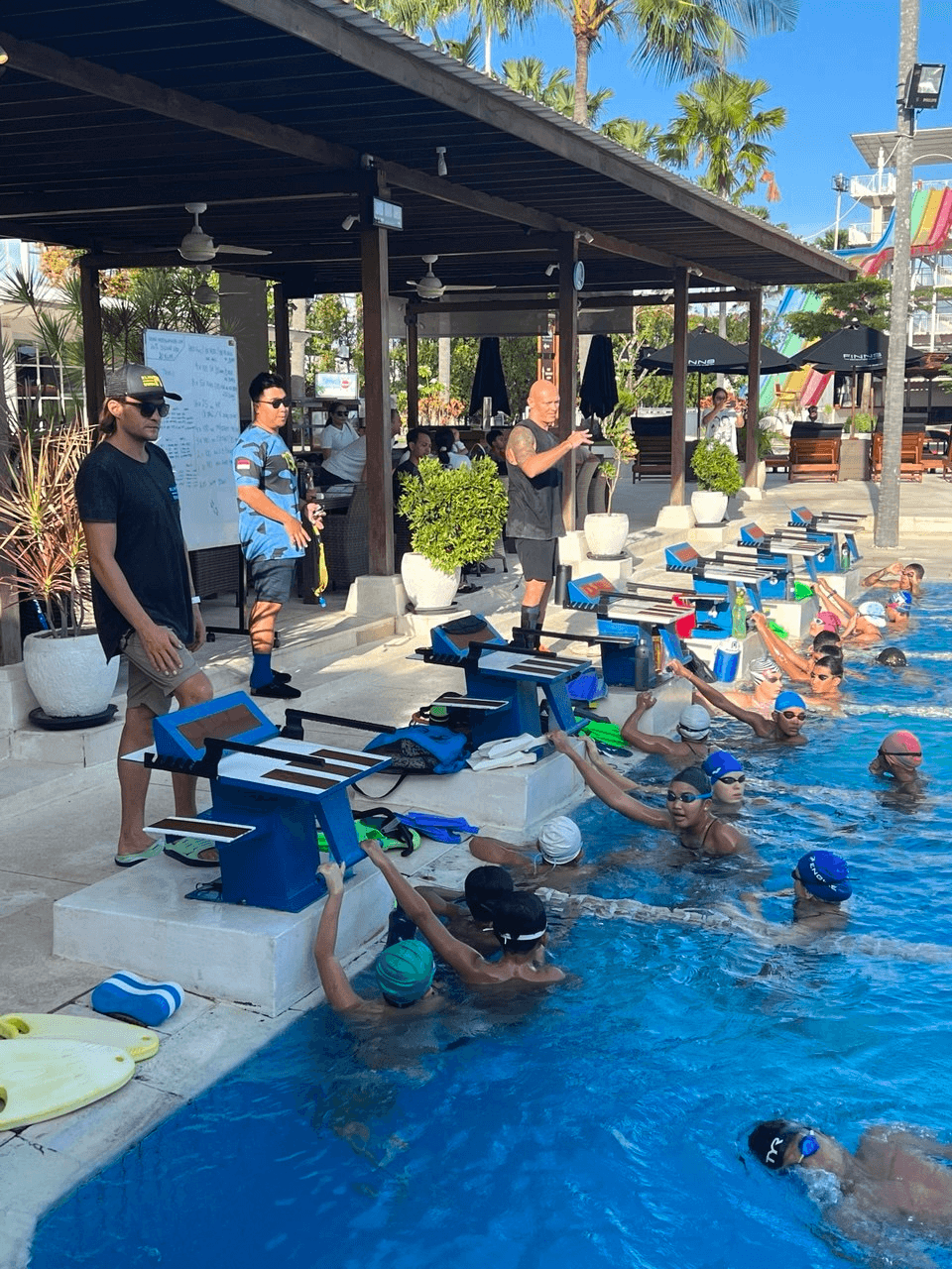 Coaches leading a pool session for swimmers at a Bali swim camp