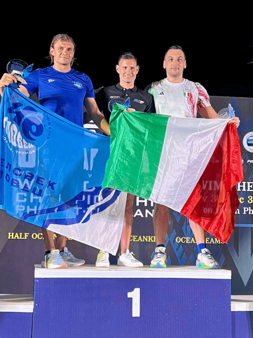 Swimmers with trophies and flags on the podium at the Phuket open-water race, 2023